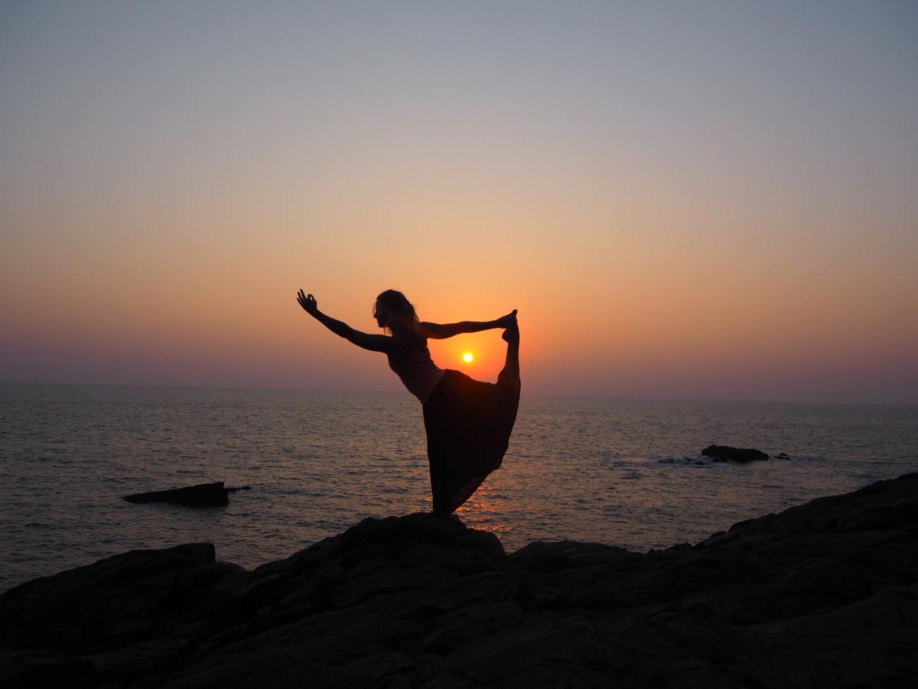 Yogi som poserer med solnedgangen